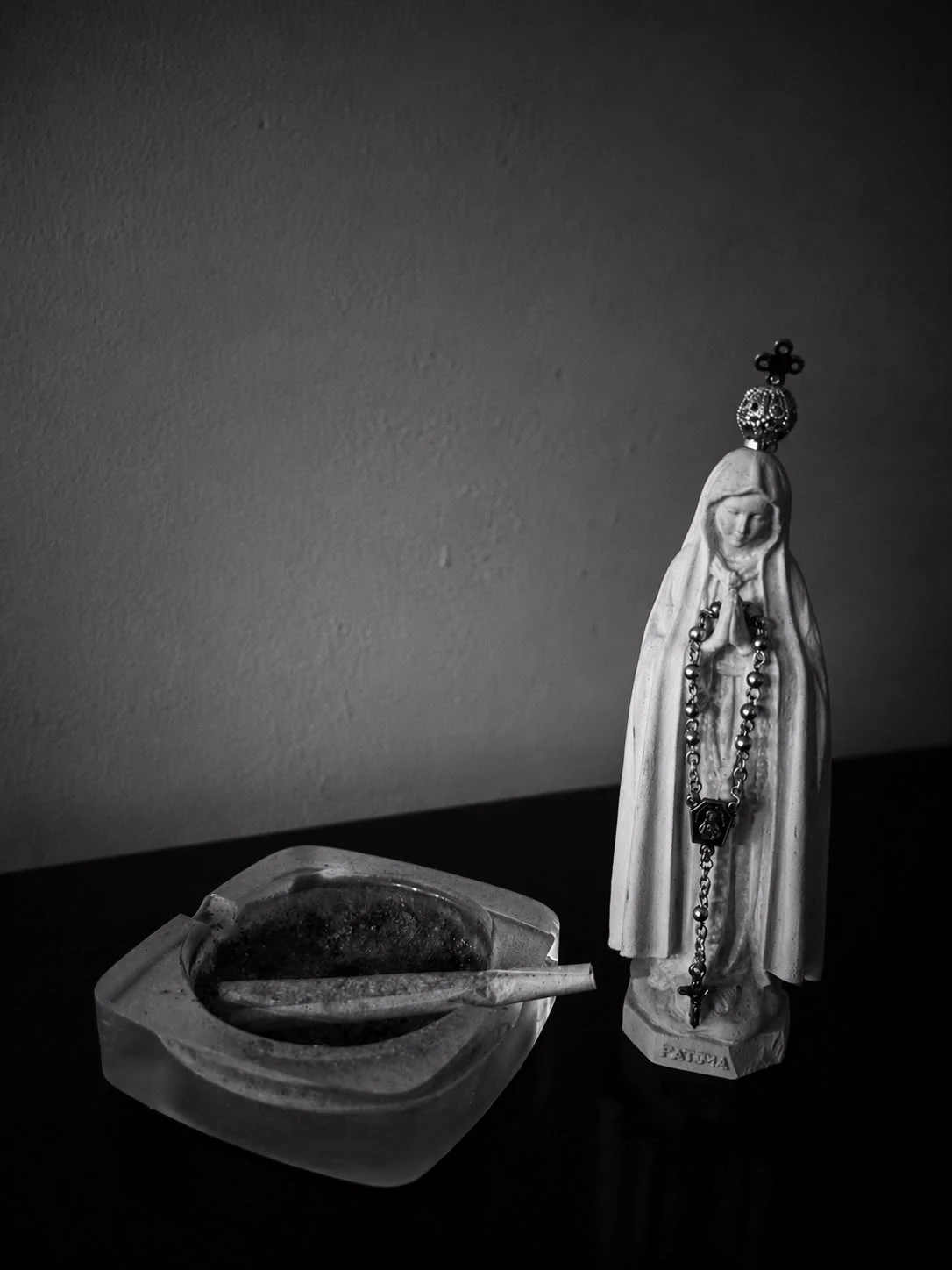 Natureza-morta a preto e branco com uma imagem religiosa e pão